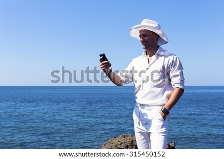 The man checked his telephone near the sea