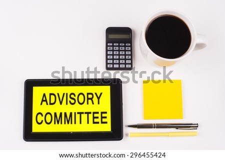 Business Term / Business Phrase on Tablet PC with a cup of coffee, Pens, Calculator, and yellow note pad on a White Background - Black Word(s) on a yellow background - Advisory Committee
