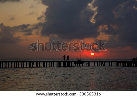 Sunset on Maldives island footbridge connecting with the thatched jetty in maldives island resort