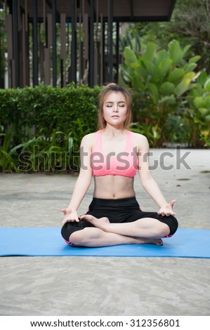 Portrait of young woman doing physical exercise in park
