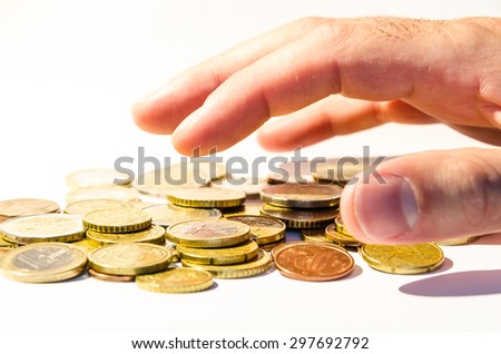 an hand is grabbing a group of different coins, (euro and cents), europe currency, over white