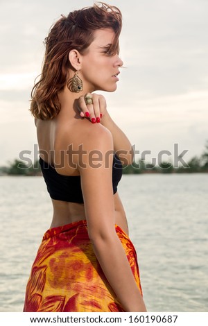 Young beautiful woman profile looking away in a tropical beach