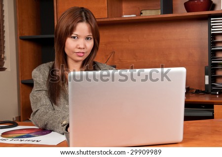 Young woman very happy working in a laptop in small office.