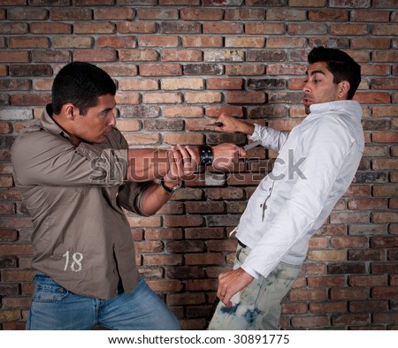 Young guys fighting in the street with knifes.