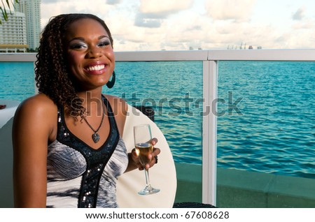 Young african american enjoys a galss of champagne in an outdoor terrace.