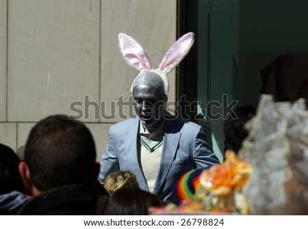 NEW YORK - MARCH 23: People watch a public entertainer as he wears rabbit ears during the Easter Parade on March 23, 2008 in New York. The tradition of the Easter Parade started in the 1870\'s.