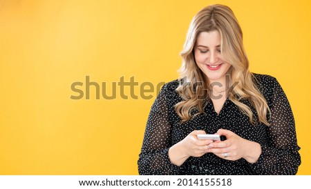 Mobile communication. Gadget people. Body positive. Weight loss app. Happy smiling overweight plus size obese woman using phone isolated on bright orange copy space background. Сток-фото © 