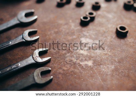 Wrenches and nuts on a rusty metal background. Beautiful art photo