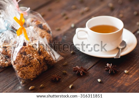 cup of green tea and the vegetarian cookies which are beautifully packed into gift packing.Dark wooden background