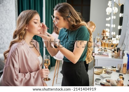 Similar – Image, Stock Photo Makeup artist doing makeup for young female artist