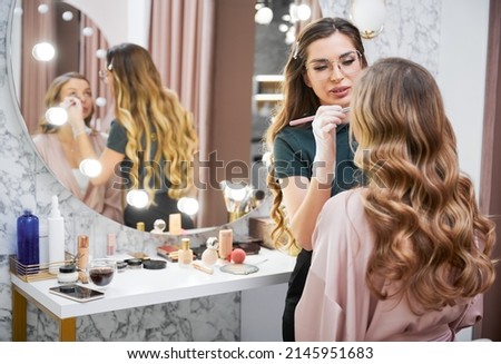 Similar – Image, Stock Photo Makeup artist doing makeup for young female artist