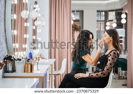 Similar – Image, Stock Photo Makeup artist doing makeup for young female artist