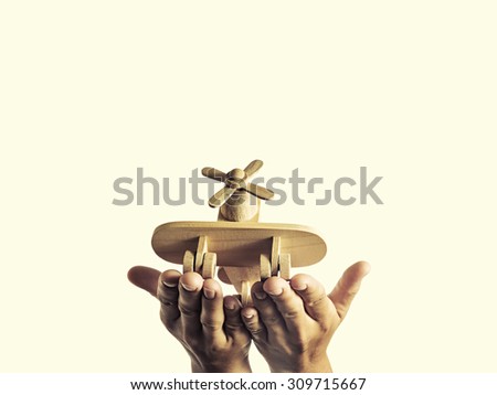 Isolated image of an open palms with a wooden hand-made aircraft