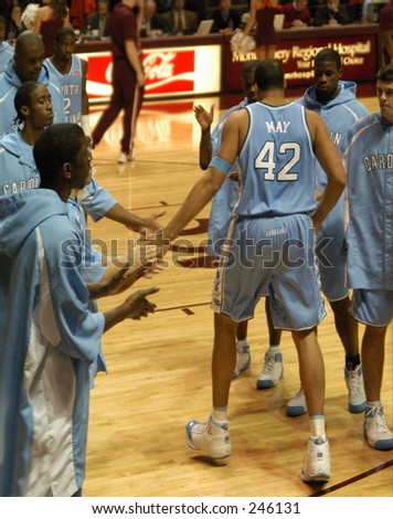 North Carolina men\'s basketball star Sean May is introduced at a recent game as he slaps hands with teammates