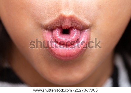 Macro of a little girl's mouth curling her tongue into a U shape, a genetic trait inherited from her parents. Photo stock © 