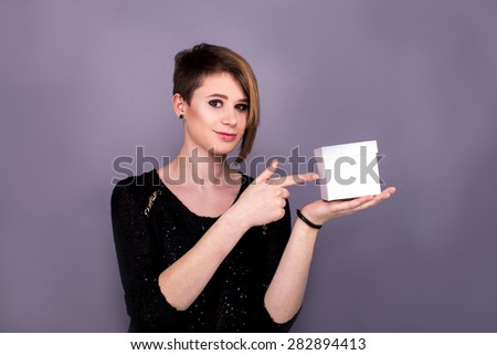 Girl pointing on a white box on a purple background