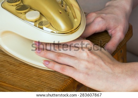 Predrying the fingers and nails in the device for manicure.