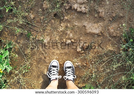 Wearing black canvas shoes on a mud
