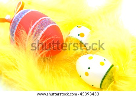 couple of Easter eggs and yellow feathers in closeup
