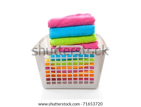 Laundry basket filled with colorful folded towels over white background