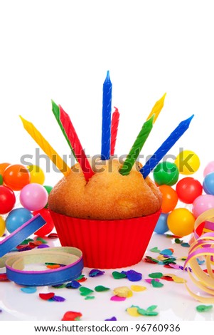 Birthday cupcake with lots of candles, party streamers and colorful confetti over white background