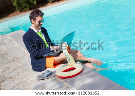 Funny Young Businessman with SwimmingTrunks next to the Pool