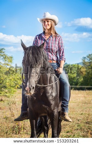 Cowgirl Riding a Black Stallion Horse