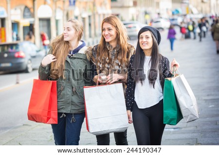 Happy Women Walking in the City with Shopping Bags. They have different Clothing styles but they seem to be in a really good friendship