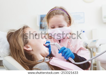 Little Girls Dentist and Patient During Dental Examination. Girl Pretending to be a Dentist is Examining Teeth of another Girl. Funny and Playful representation of Dentist and Dental Theme.