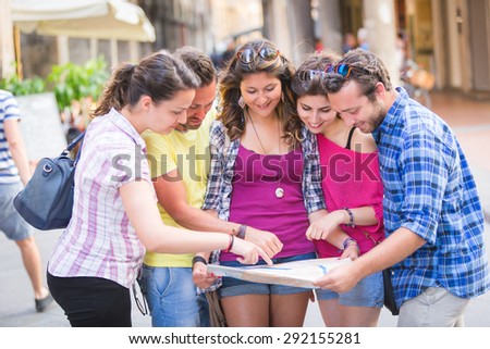 Tourists looking at city map with typical Italian street on background. The photo was taken in Pisa but could also be used for Rome, Florence or Milan.