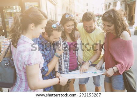 Tourists looking at city map with typical Italian street on background. The photo was taken in Pisa but could also be used for Rome, Florence or Milan.