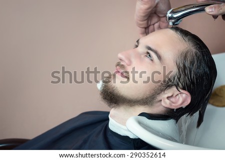 Young man having his hair washed in a hairdressing salon or barber shop.