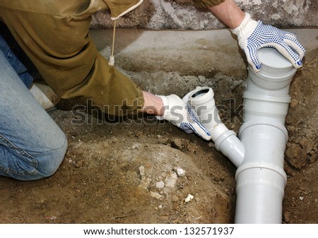 Plumber assembling pvc sewage pipes