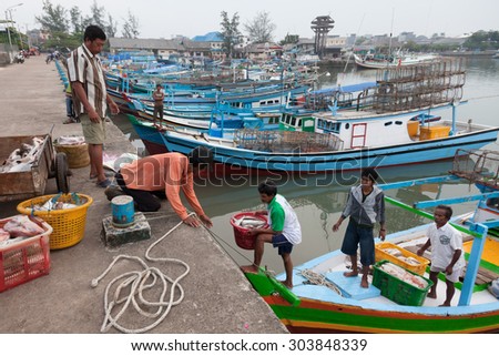 Belitung Island, Indonesia - 30 May 2011: Fishermen in a remote island Belitung, Indonesia, loading the catch to the wharf, ready to be delivered to the nearby fish market.