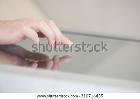 fingers of a young girl on the touchpad. Use in the banking sector