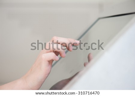 fingers of a young girl on the touchpad. Use in the banking sector