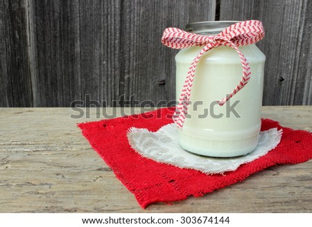 Top of milk with red textile on vintage wooden table