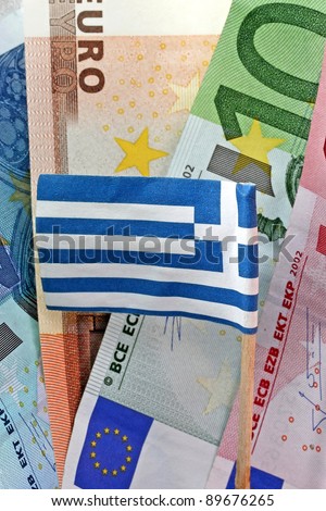 Euro banknotes and Greek flag