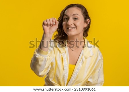 Knock-knock who is there. Excited young woman knocking door gesture asking who is at home, feeling embarrassed, no idea, being clueless and uncertain. Girl isolated alone on studio yellow background Сток-фото © 