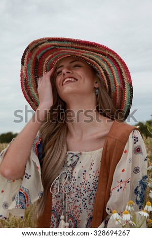 beautiful portrait of a teenage girl laughing wearing a floppy hat