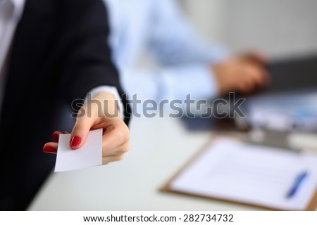 Female hand holding a blank business card .