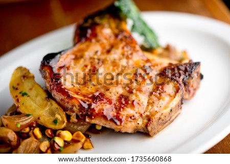Pork chops. Pork chops seasoned with cracked black pepper and grilled. Pork served with classic steakhouse side dishes: asparagus and mashed potatoes. Classic fine dining entree. Сток-фото © 