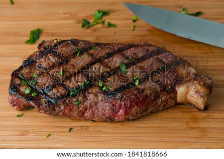 Steaks. Grade A grass fed angus beef steaks. Tenderloin, filet mignon, New York strip, bone in rib-eye grilled medium rare on outdoor wood-fired grill. Classic American steakhouse entree favorite. Photo stock © 