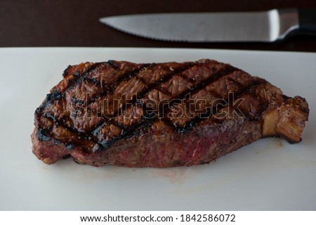 Steaks. Grade A grass fed angus beef steaks. Tenderloin, filet mignon, New York strip, bone in rib-eye grilled medium rare on outdoor wood-fired grill. Classic American steakhouse entree favorite. Photo stock © 