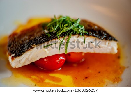 Sea bass fillet. Fresh sea bass  seasoned with salt and pepper, sautéed in olive oil, lemon juice, fresh herbs, grilled and served with potatoes. Classic fine dining restaurant entree. Сток-фото © 