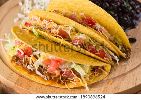 Tacos. Crispy flour and corn tortillas filled with sausage, bacon, beef, cheese, sour cream, salsa and guacamole and served with rice and beans. Classic Tex-Mex or Mexican restaurant entrée favorite. Сток-фото © 