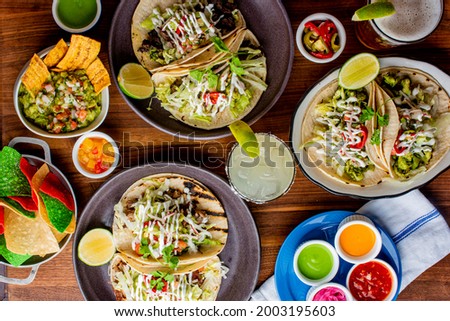 Tacos. Crispy flour and corn tortillas filled with sausage, bacon, beef, cheese, sour cream, salsa and guacamole and served with rice and beans. Classic Tex-Mex or Mexican restaurant entrée favorite. Сток-фото © 