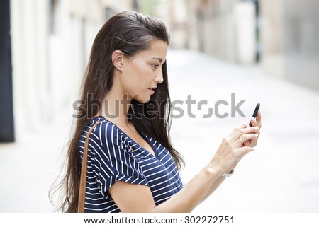A portrait of a beautiful woman texting with her phone