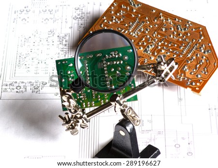 the study of the electrical board with a magnifying glass .