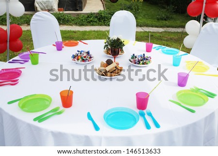 The image of plastic plates and dishes on the open-air served table